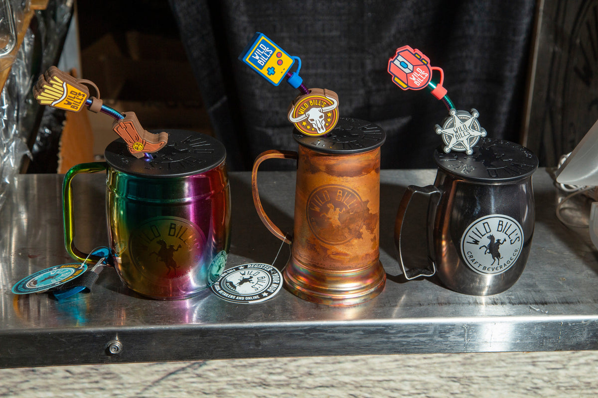 Three Wild Bill's mugs with toppers on a steel table